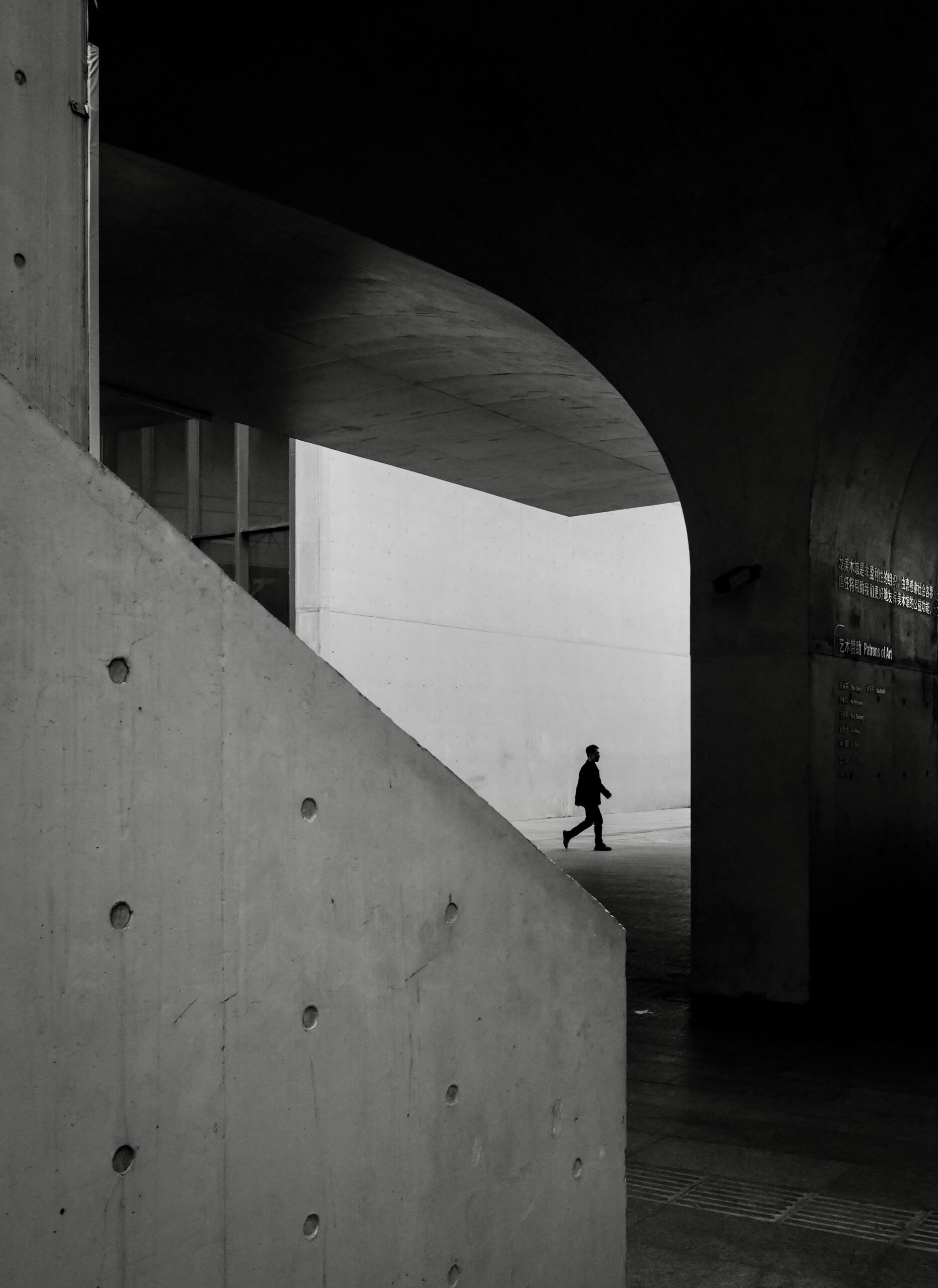 Black and white photo of a man walking in the dark